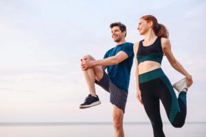 Fit couple stretching outdoors, promoting a healthy lifestyle for optimal fertility testing results.