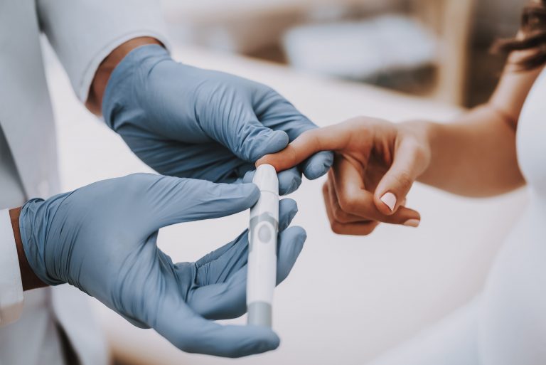 Healthcare professional conducting a blood test to check glucose levels, highlighting the connection between diabetes and its impact on fertility