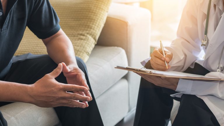 A doctor explains the fertility challenges with a male patient, discussing concerns related to male hormones.